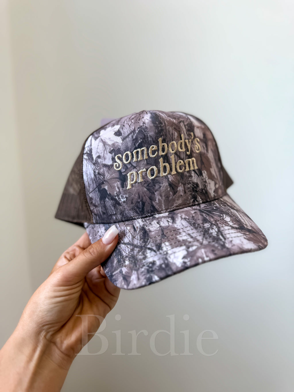 Somebody’s Problem Camo Trucker Hat